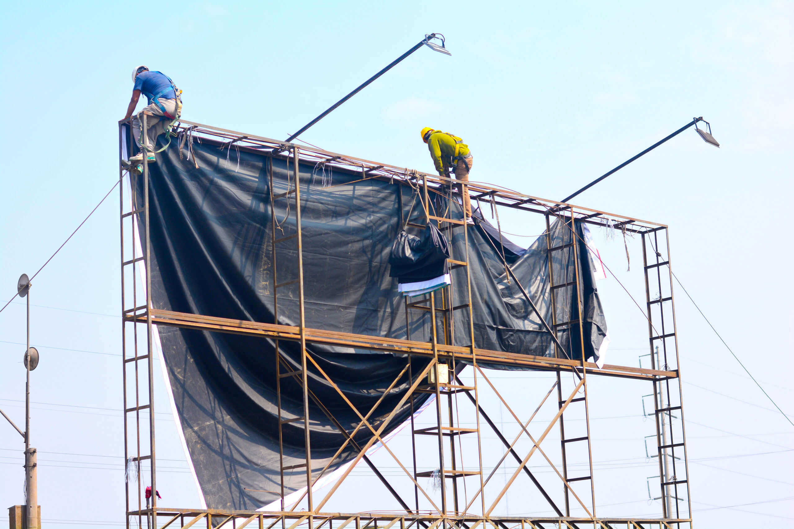 Two billboard installers doing their work.