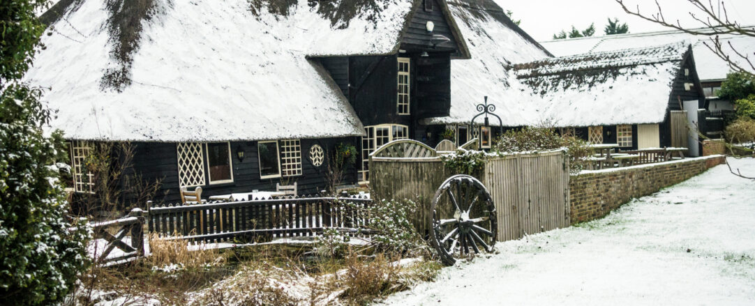 Thatched Roof in the snow Thatch roof cottage covered in show in the winter