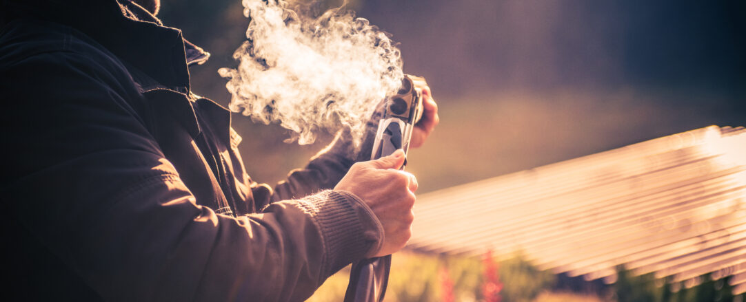 Caucasian Male Hunter After a Successful Shot with Smoke Coming Out of the Barrel of His Shotgun. Shooting and Hunting Theme.