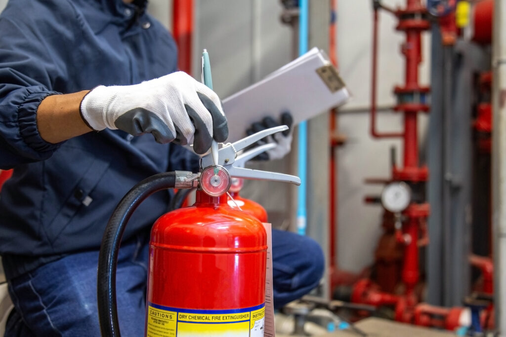 Engineer are checking and inspection a fire extinguishers tank in the fire control room for safety training and fire prevention.