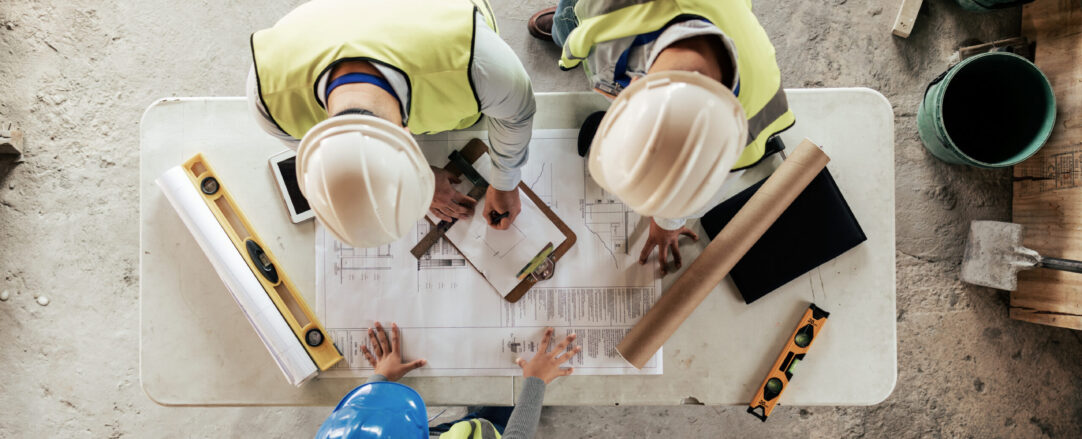 Asbestos contractors looking at blueprints.